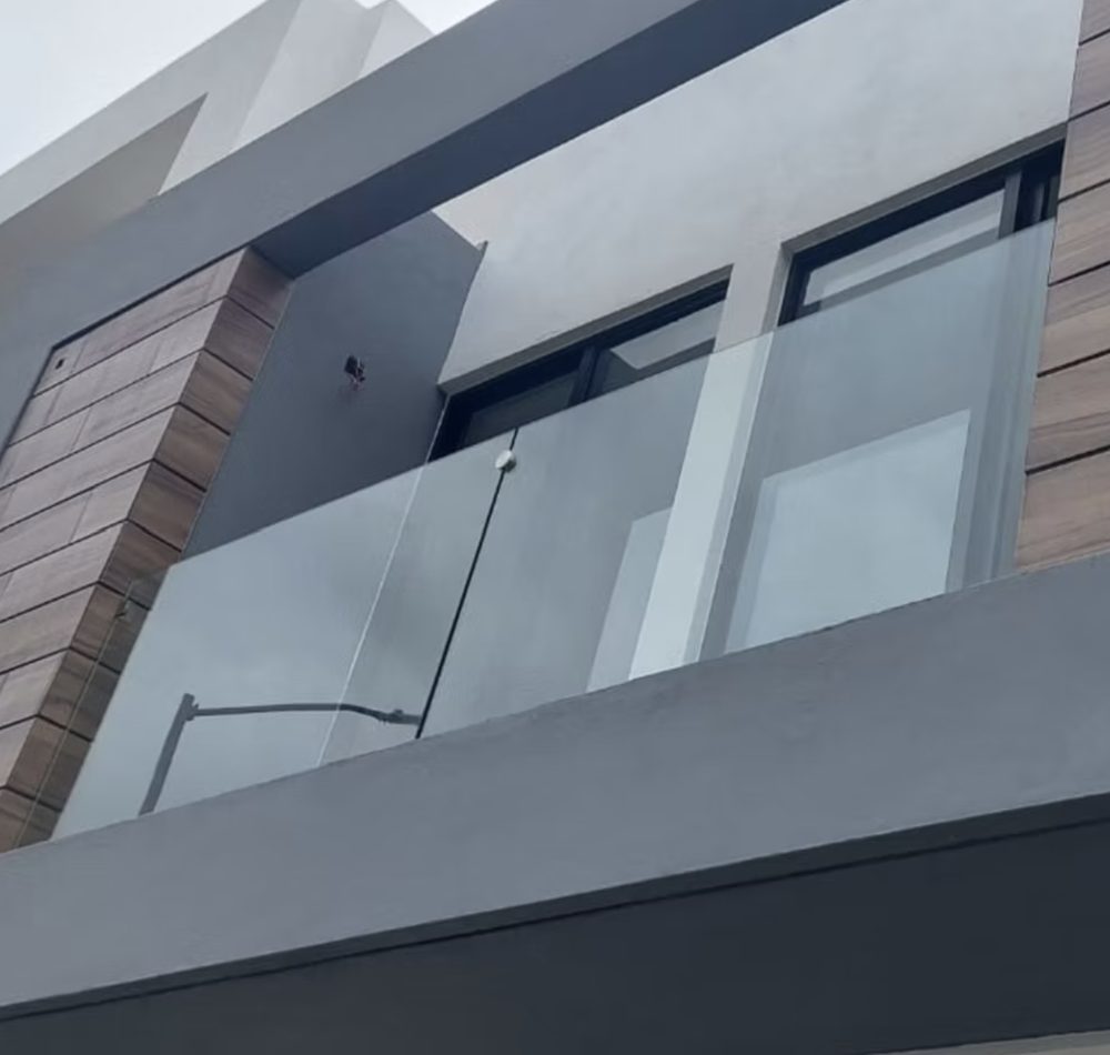 Fachada con ventanas de aluminio y barandal de cristal en Zapopan