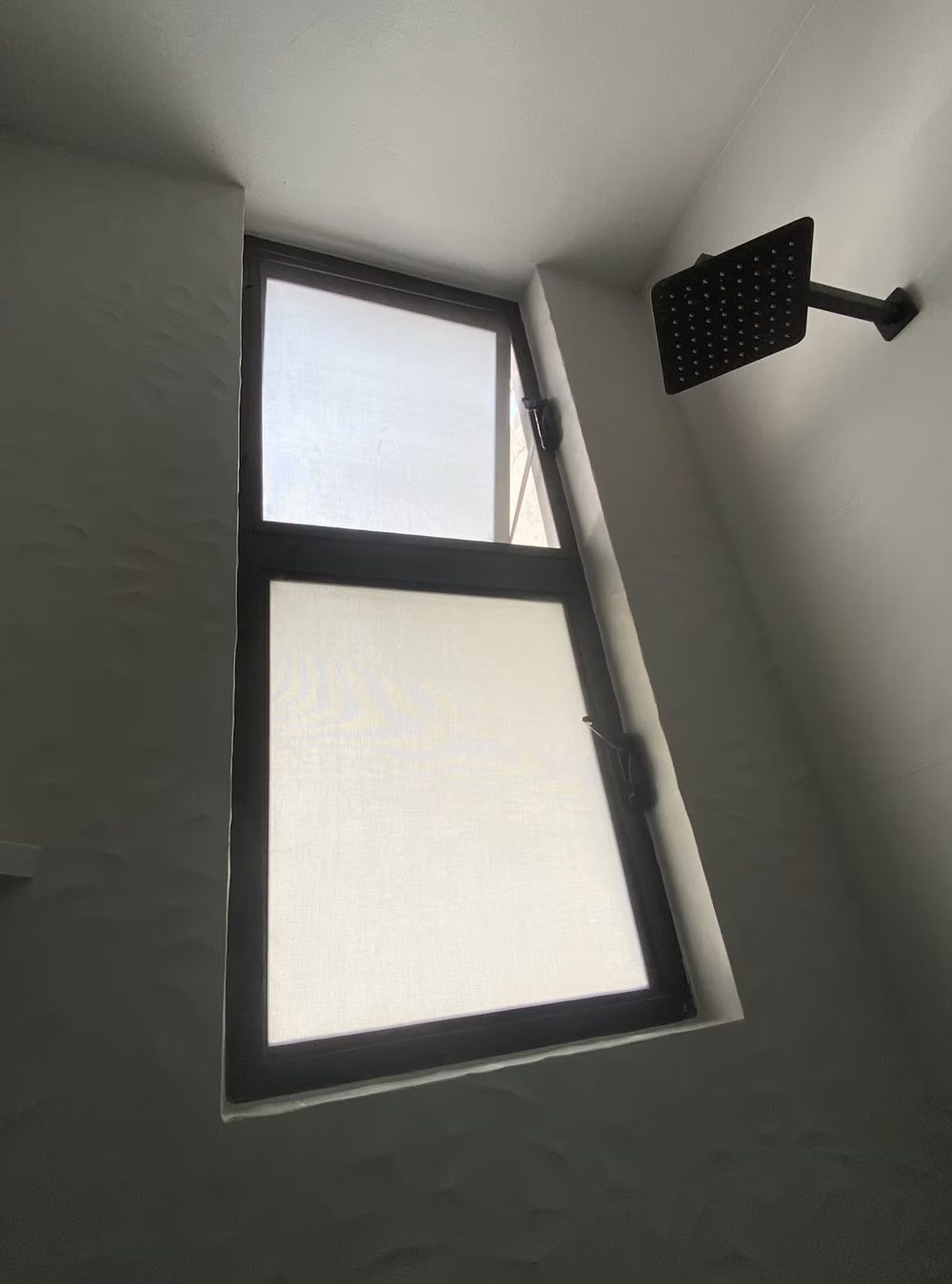 Ventana de aluminio proyectable con cristal esmerilado en un baño