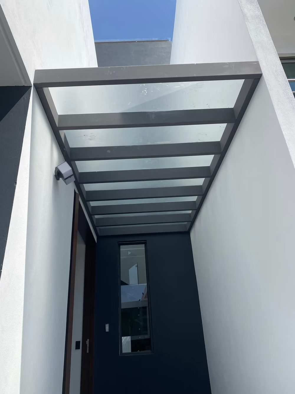 Entrada con techo de cristal y ventanas de aluminio en Zapopan